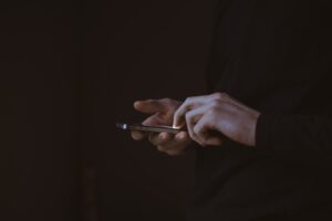 Person granskar en smartphone i mörk miljö