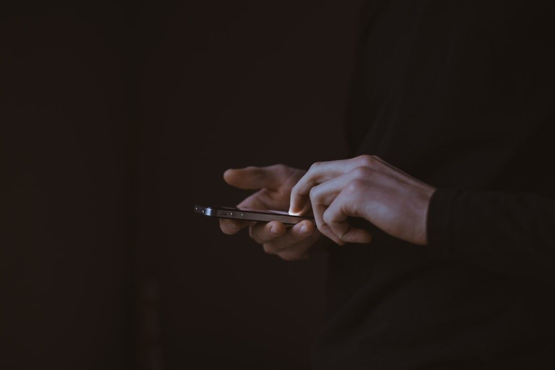 Person granskar en smartphone i mörk miljö